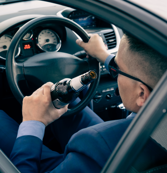 man driving while drinking alcohol