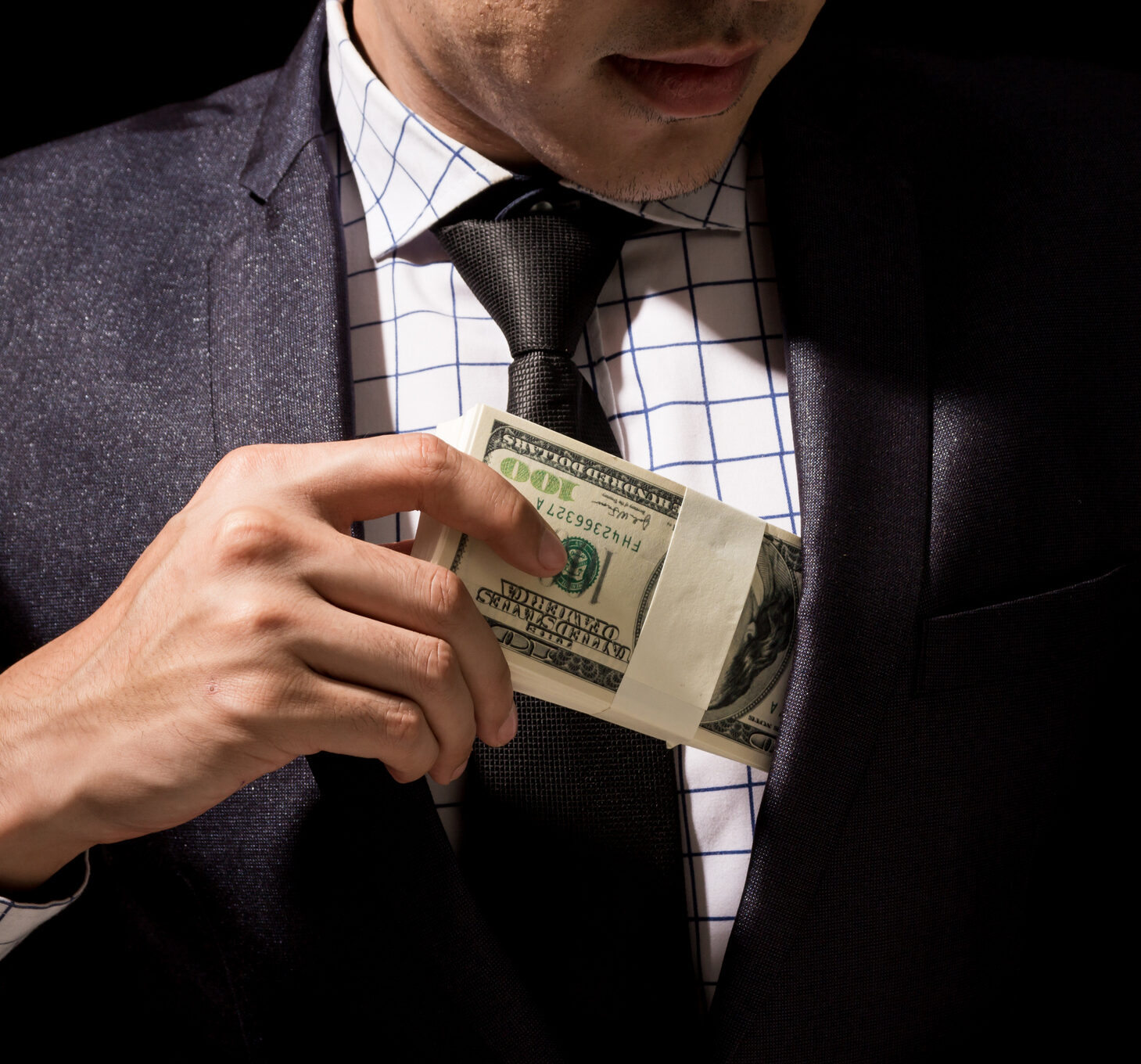 Businessman putting dollar banknotes into pocket