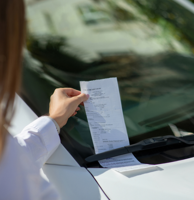 Woman taking a traffic ticket from the windshield